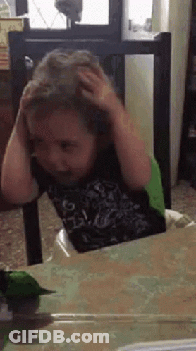 Young Boy Scratching Head In High Chair GIF