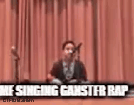 Young Boy Singing Into Microphone On Stage GIF