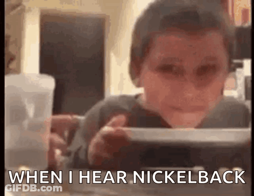 Young Boy Sitting At Table Saying When I Hear Nickelback GIF