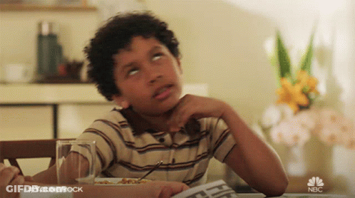 Young Boy Sitting At Table With Newspaper And NBC Logo GIF
