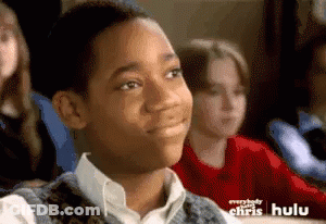 Young Boy Sitting In Classroom With Hulu Ad Behind Him GIF