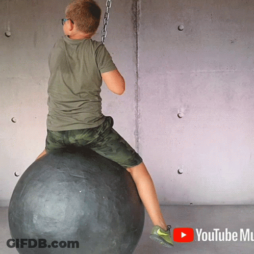 Young Boy Sitting On Black Ball With YouTube Mu GIF