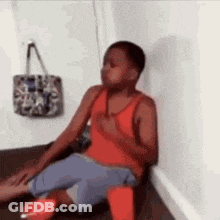 Young Boy Sitting On Floor Next To Wall And Purse GIF