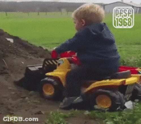 Young Boy Sitting On Toy Bulldozer In Field GIF