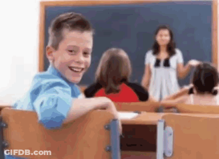 Young Boy Smiling In Classroom With Teacher GIF