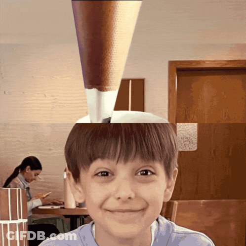 Young Boy Smiling In Front Of Woman At Table GIF