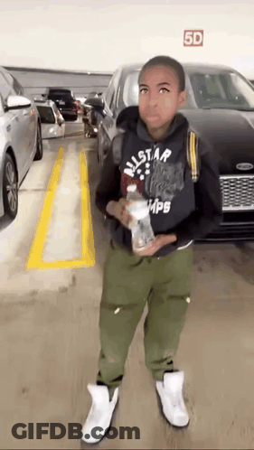 Young Boy Standing In Parking Garage With Bottle Of Water GIF