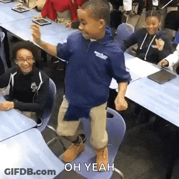 Young Boy Standing On Chair In Classroom GIF