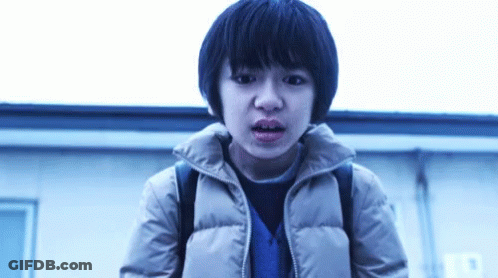 Young Boy With Backpack Standing In Front Of Building GIF