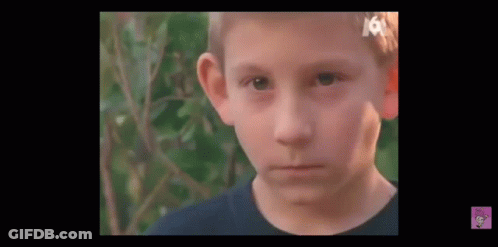 Young Boy With Bandage On Head Looking At Camera GIF