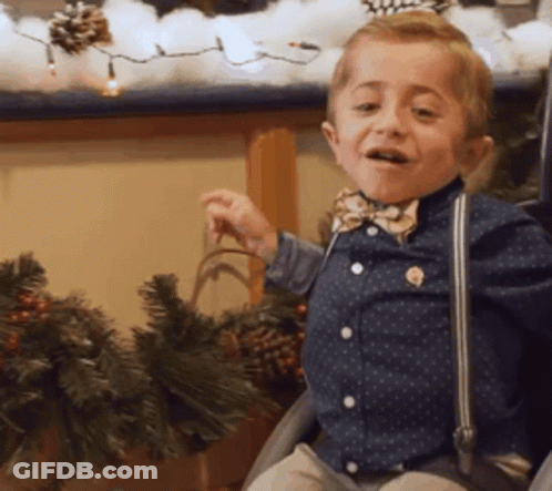 Young Boy With Bow Tie And Suspenders In Chair GIF