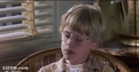 Young Boy With Glasses Sitting By Window GIF
