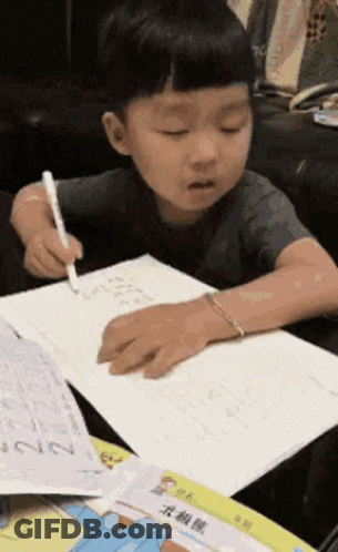 Young Boy Writing At Table GIF