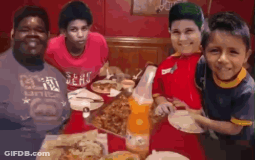 Young Boys Eating Pizza Around Table GIF