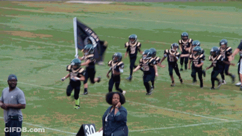 Young Football Players In Black And Gold Uniforms Number 27 GIF