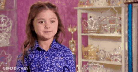 Young Girl In Blue Shirt With Crown Shelf GIF