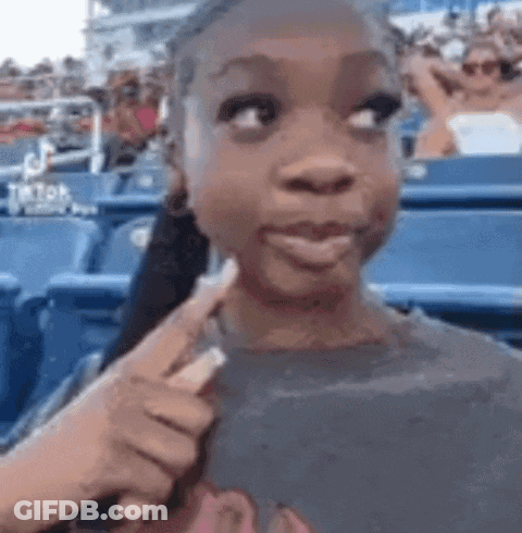 Young Girl In Stadium Pointing Stick At Face GIF
