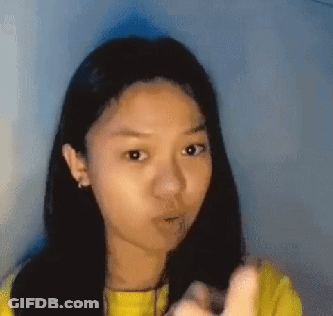 Young Girl In Yellow Shirt Pointing With Funny Face GIF