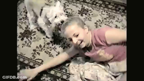 Young Girl Laying On Floor With White Dog GIF