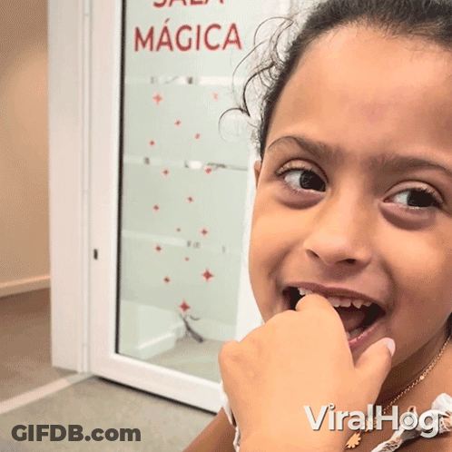Young Girl Looking At Camera With Sala Magica Sign GIF