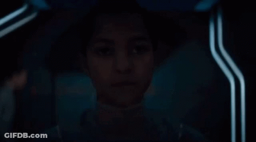 Young Girl Sitting In Dark Room Looking GIF
