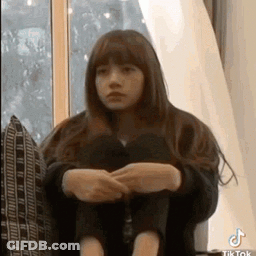 Young Girl Sitting On Couch With Legs Crossed GIF