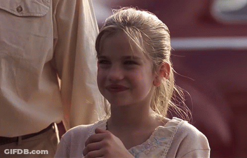 Young Girl Smiling In White Shirt With Blue Embroidery GIF