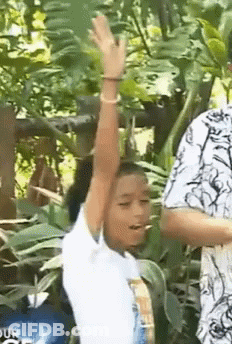 Young Girl Standing In Woods With Arm Up GIF