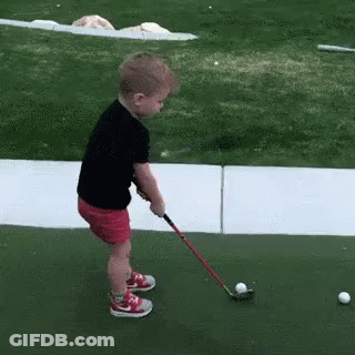 Young Girl Swinging Golf Club At Ball GIF