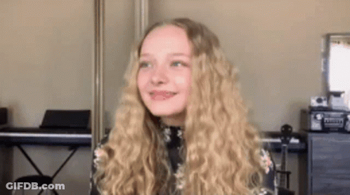 Young Girl With Blonde Hair In Front Of Piano GIF
