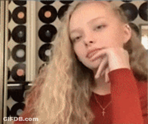 Young Girl With Long Blonde Hair And Red Shirt And Necklace GIF