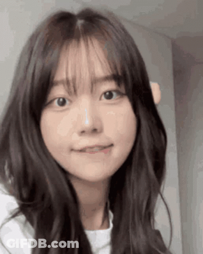 Young Girl With Long Hair And Bangs Looking At Camera GIF