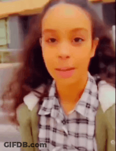 Young Girl With Pigtails In Plaid Shirt And Green Cardigan GIF