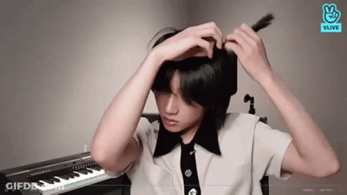 Young Man Adjusting Hair At Piano GIF
