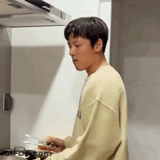 Young Man Cooking In Kitchen In Yellow Sweatshirt GIF