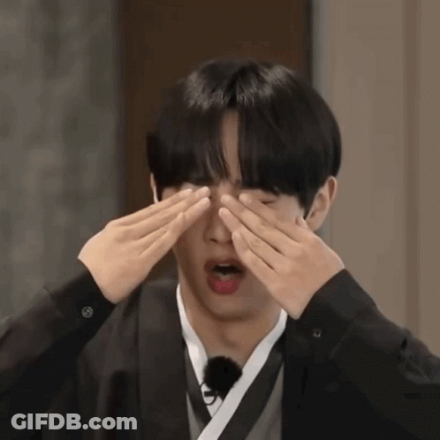 Young Man Covering Eyes In Black Jacket GIF