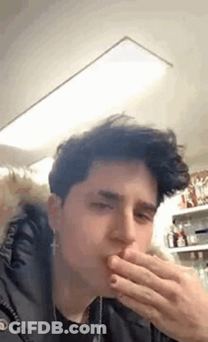 Young Man Covering Mouth While Eating GIF