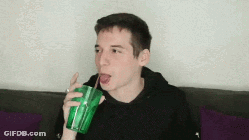 Young Man Drinking Through Straw From Green Cup GIF