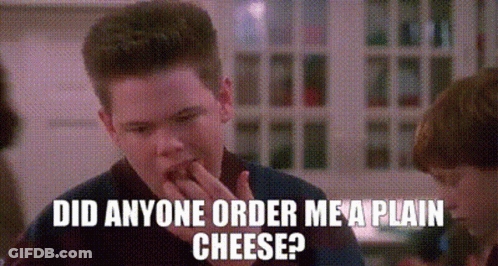 Young Man Eating Cheese Talking To Another Man GIF