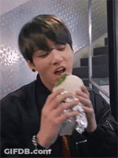 Young Man Eating Foil-Wrapped Hamburger GIF