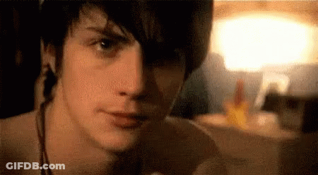 Young Man Face In Dark Room With Lamp GIF