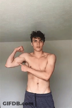 Young Man Flexing Muscles And Pointing At Arm GIF