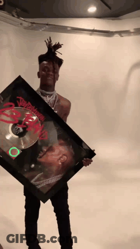Young Man Holding Framed Picture Of Dreadlocked Man Named Jay Z GIF
