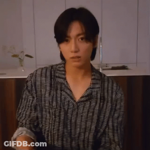 Young Man Holding Microphone In Striped Shirt GIF