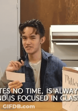 Young Man Holding Paper Saying Yes No Time Is Always And Is Focused In Class GIF
