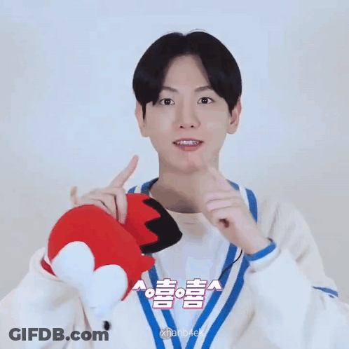 Young Man Holding Stuffed Animal With Chinese Writing GIF