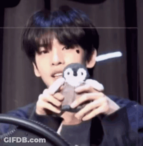 Young Man Holding Stuffed Penguin GIF