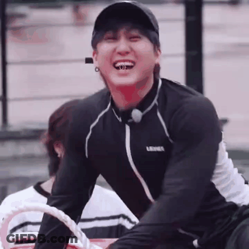Young Man In Baseball Cap And Black Shirt Sitting On Boat GIF
