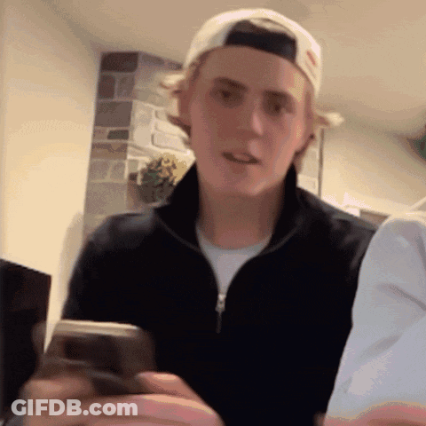 Young Man In Baseball Cap Holding Cellphone GIF