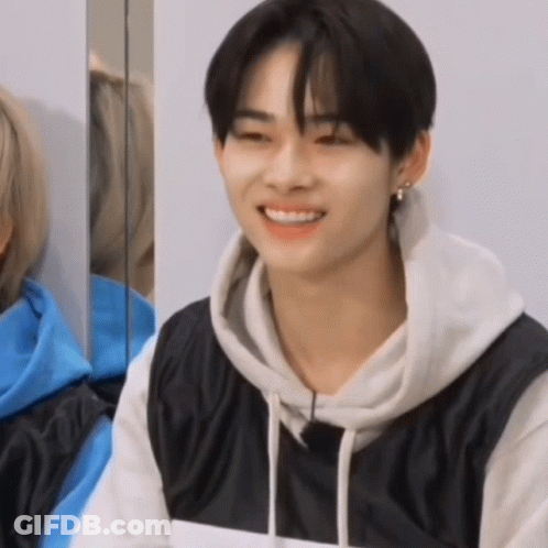 Young Man In Black And White Hoodie Smiling In Mirror GIF
